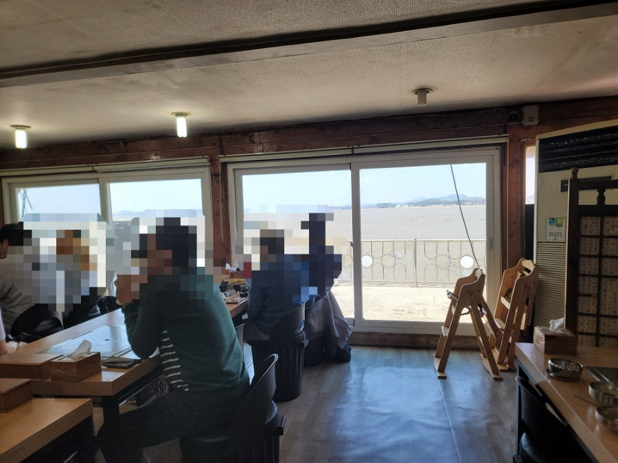 창밖으로 바다가 보이는 매장 내부. 자리에 앉아 식사하며 풍경을 함께 즐길 수 있습니다.