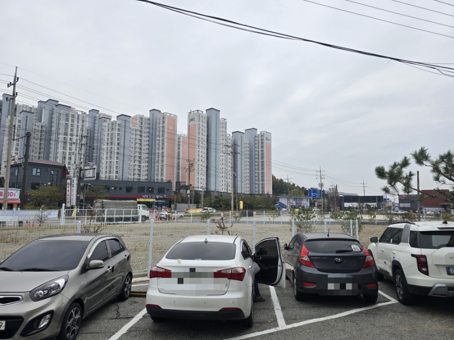 매장 앞 주차 공간. 인근 아파트 단지를 배경으로 넉넉한 주차 여건을 확인할 수 있습니다.