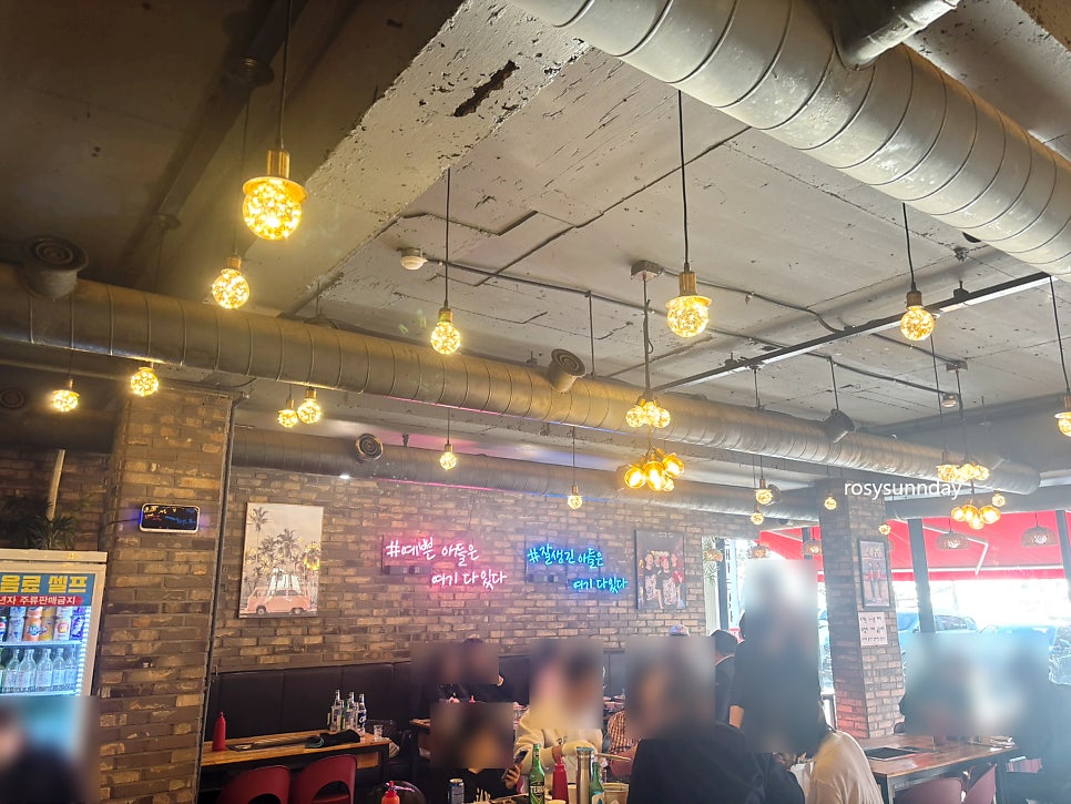 배관과 전구 조명, 브릭 벽면이 어우러진 매장 내부. 캐주얼하면서도 아늑한 분위기입니다.