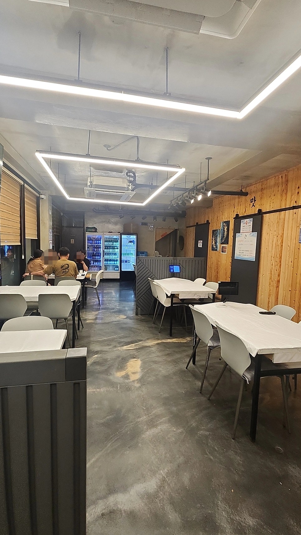 매장 내부. 깔끔하게 정돈된 테이블과 조명이 코스요리를 즐기기 좋은 분위기를 만듭니다.