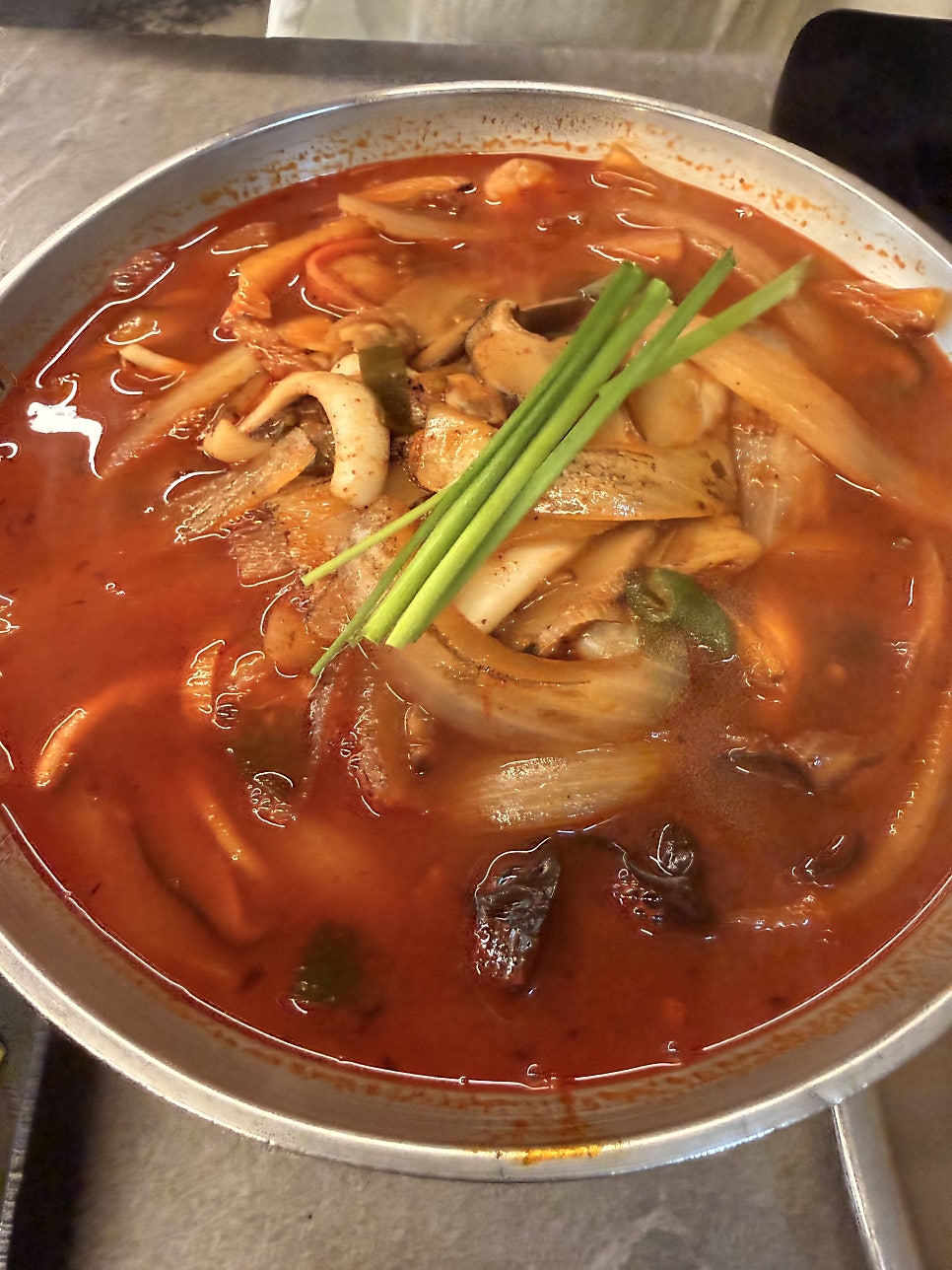문어짬뽕. 깊은 빨간 국물과 큼직한 문어 조각, 파 토핑이 돋보입니다.