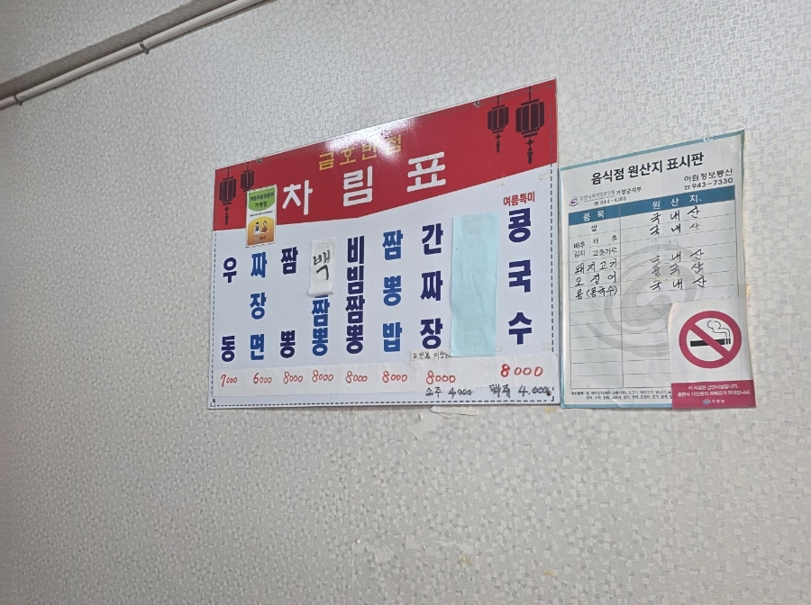 메뉴판. 짜장면, 짬뽕, 간짜장, 우동 등의 메뉴와 가격이 적혀 있습니다.