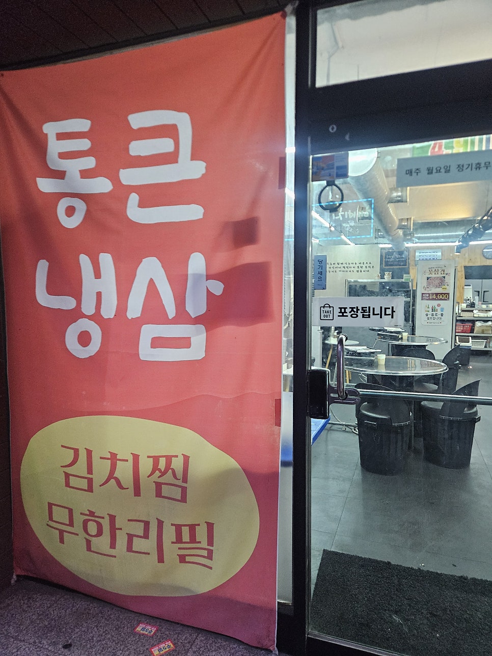'김치찜 무한리필'을 강조한 입구 배너. 포장 주문도 가능하고 매주 월요일은 정기휴무입니다.