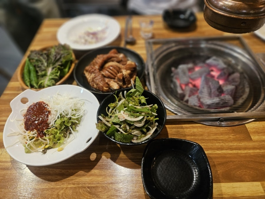기본으로 나오는 쌈채소와 겉절이, 초벌구이한 돼지갈비. 테이블 화로에 올려 마저 구워 먹는 방식입니다.