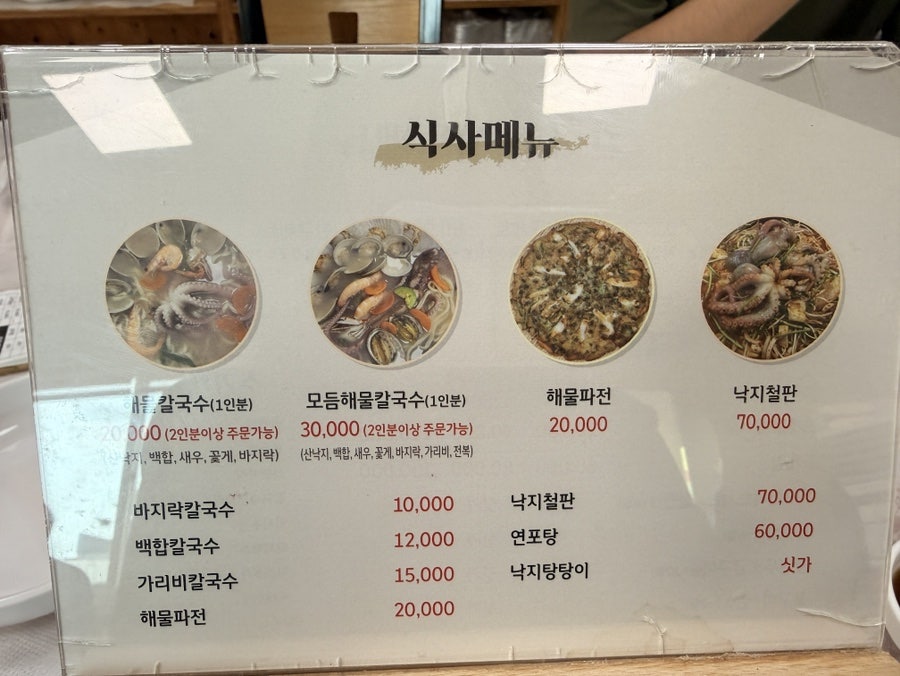 실제 매장 메뉴판. 바지락칼국수 1만원, 백합칼국수 1만2천원, 가리비칼국수 1만5천원, 해물파전 2만원으로 적혀 있습니다.