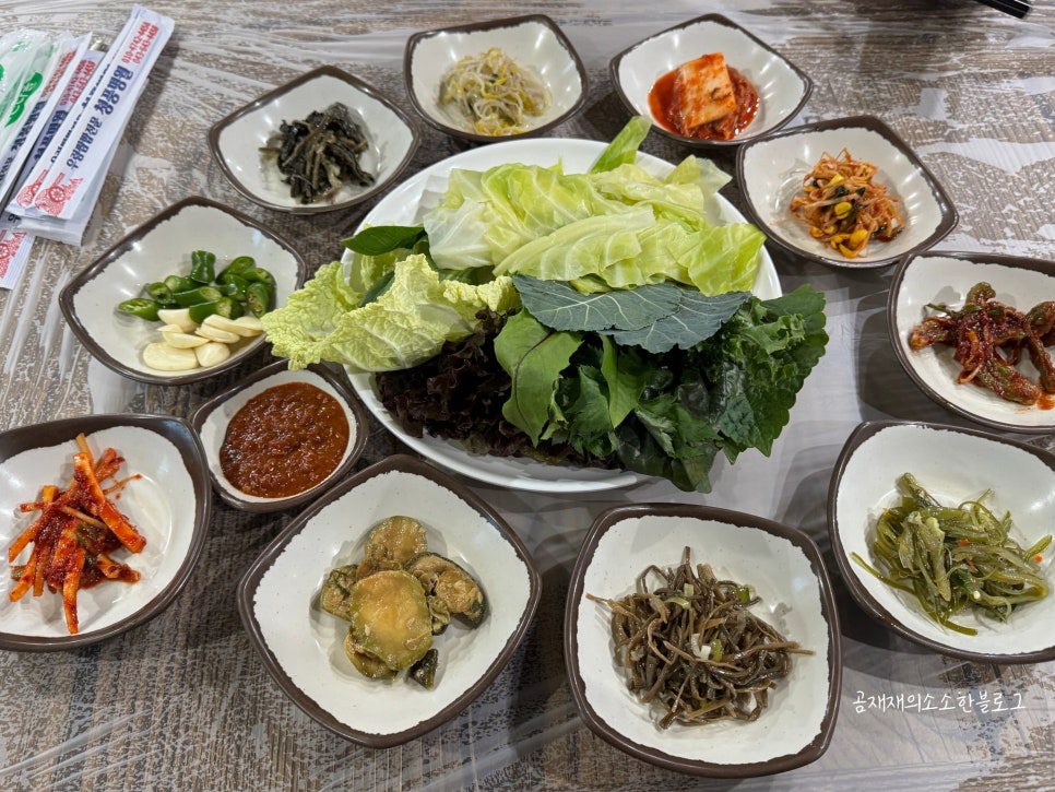 쌈채소와 밑반찬이 상을 가득 채운 모습. 반찬 가짓수가 많아 젓가락 갈 곳이 많습니다.