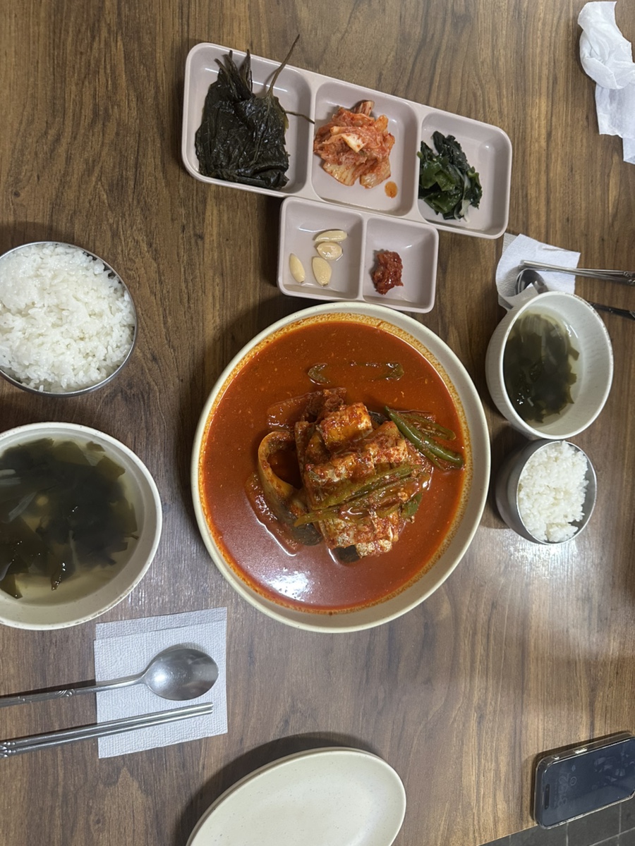 테이블 위 갈치조림과 밑반찬 구성. 김, 김치, 마늘, 초고추장이 함께 나옵니다.