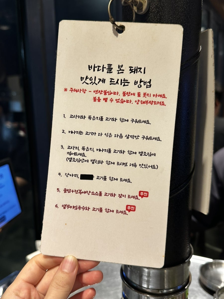 테이블마다 놓인 '맛있게 먹는 방법' 안내 카드. 고사리·묵은지·마늘을 멜조림에 찍어 먹는 순서와 추천 조합을 알려줍니다.