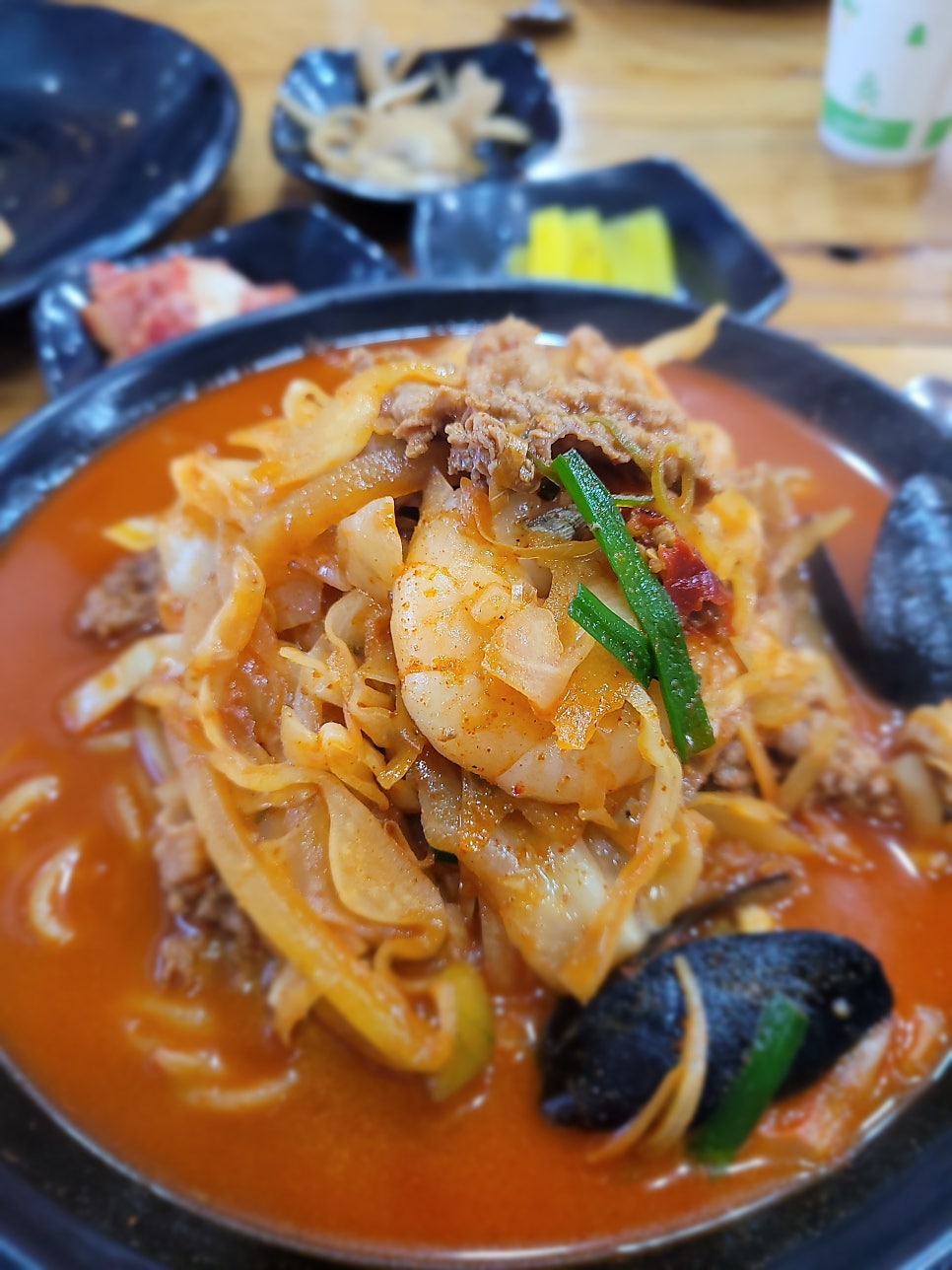 짜장면. 노란 면 위에 검은 짜장 소스가 올려져 있으며, 푸짐한 양감이 돋보입니다.