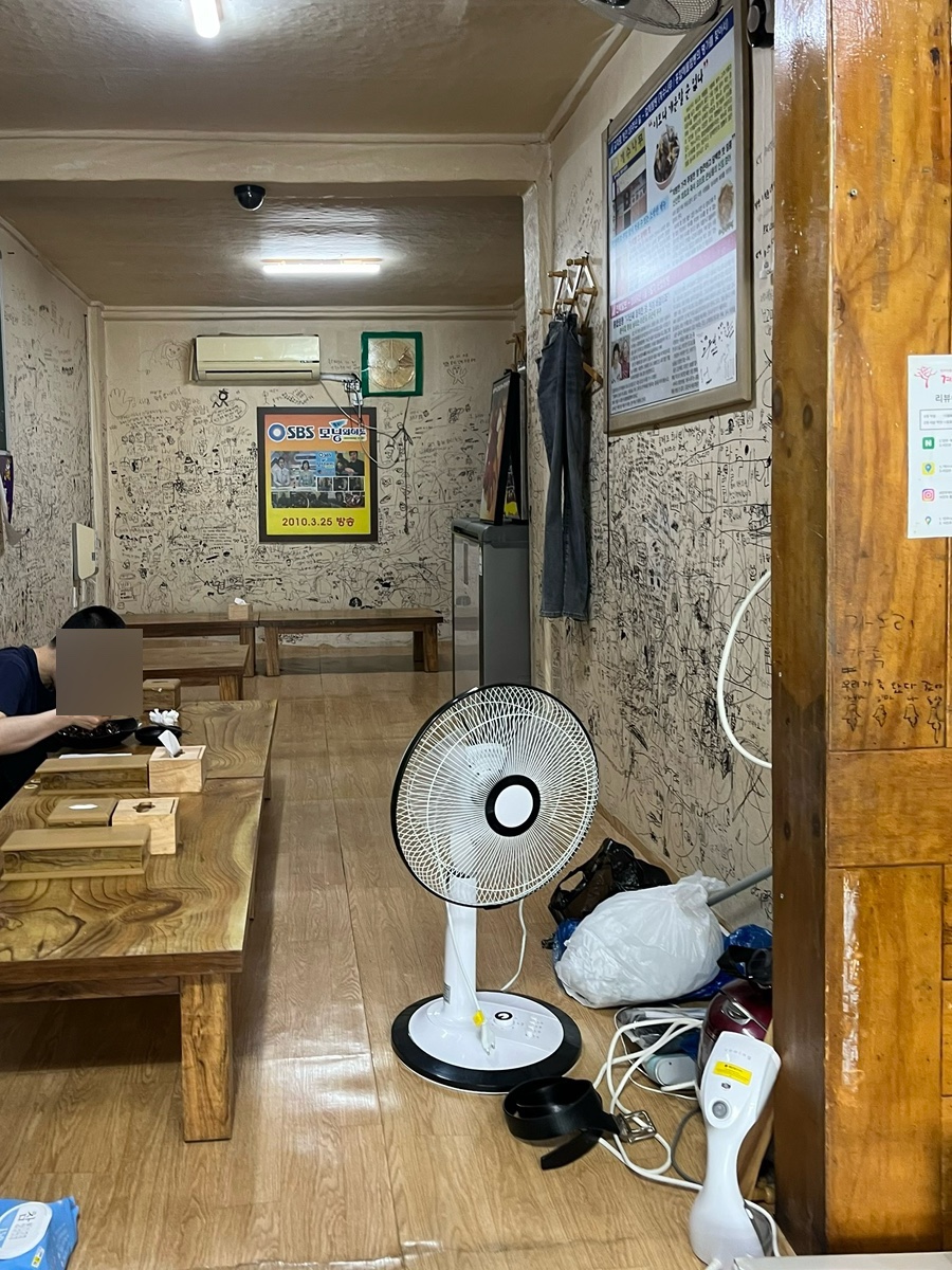 가게 내부 분위기. 손님들의 낙서가 가득한 벽면과 테이블이 오랜 역사를 말합니다.