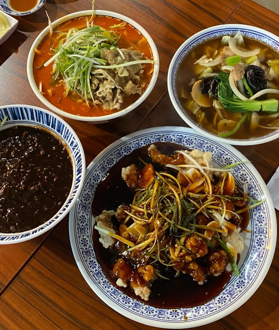 홍교리의 대표 메뉴들. 진하고 깊은 국물에 우삼겹이 담긴 우삼겹면과 탕수육, 짬뽕, 그리고 반찬들이 테이블을 채웁니다.