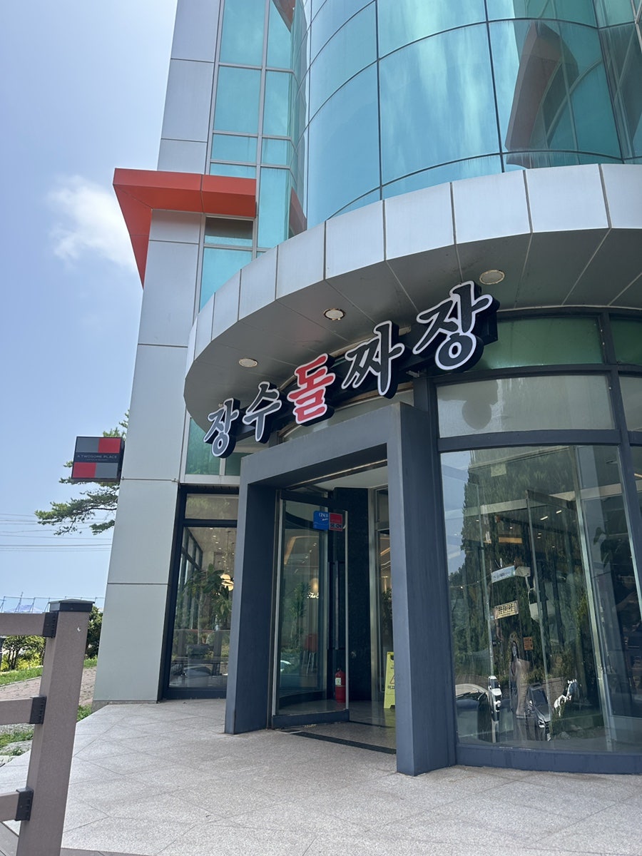 통유리 건물에 크게 붙은 장수돌짜장 삼척점 간판