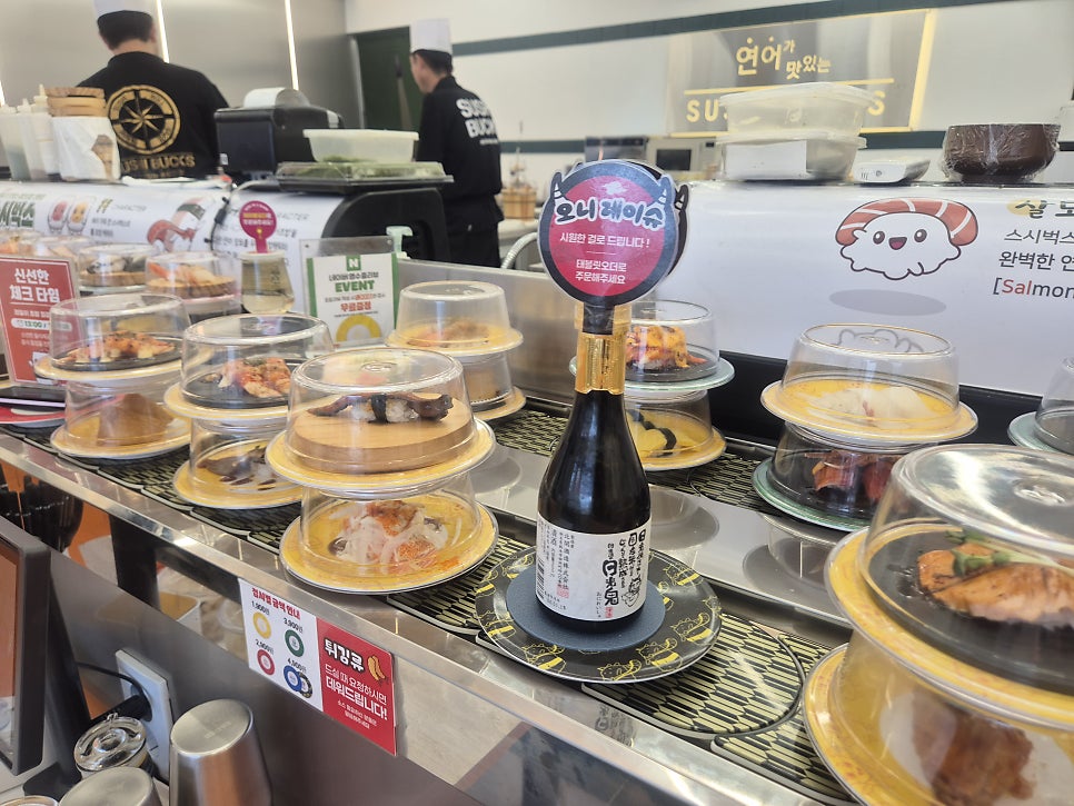 매장 안쪽에서 직원들이 초밥을 즉석으로 준비하는 모습입니다.