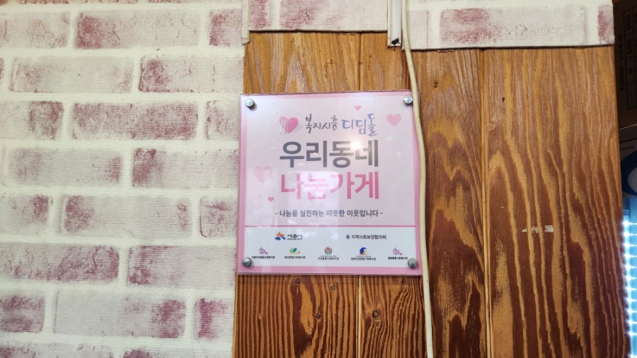 가게에 붙은 '우리동네 나눔가게' 표지. 지역 나눔 활동에 참여하는 가게임을 알 수 있습니다.