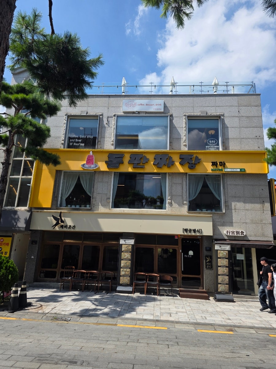 노란 간판의 돌판짜장 짜마 입구