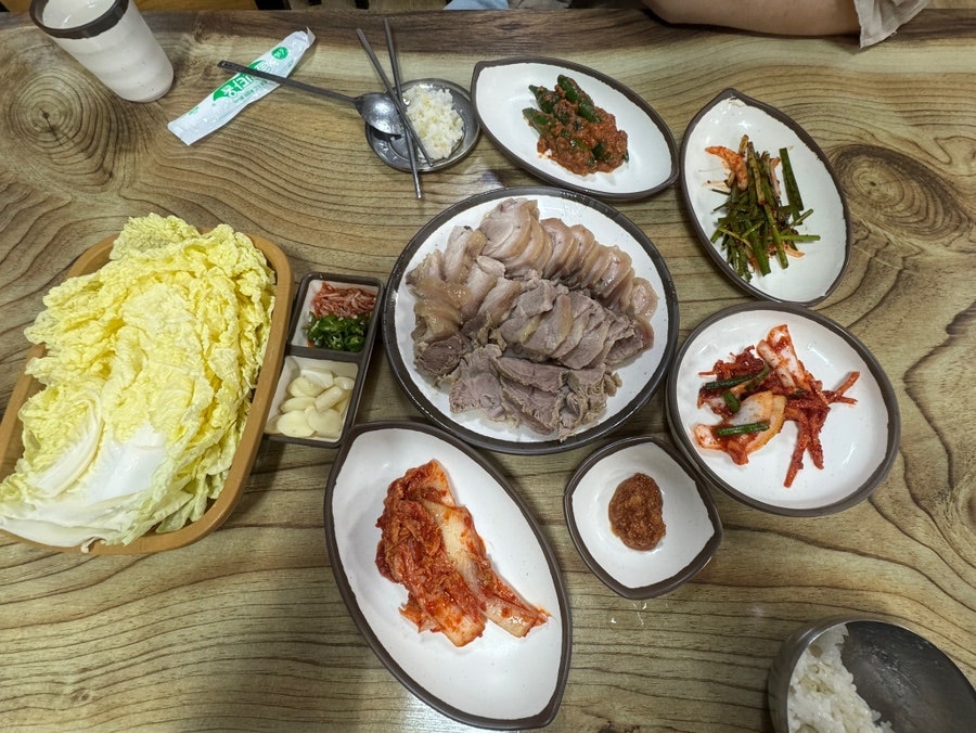 수육 중자와 함께 나온 밑반찬 상차림. 배추, 마늘, 쌈장, 김치 여러 종류가 넉넉하게 곁들여져요.